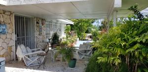 um pátio exterior com cadeiras brancas e plantas em Bajamar Your Second Home Guest Property em Freeport