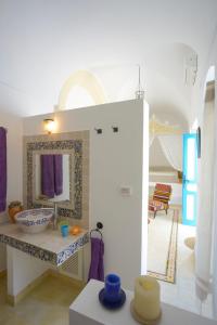 een badkamer met een wastafel en een spiegel in een kamer bij Dar R'Bat, Maison d'Hôtes de charme in Nabeul