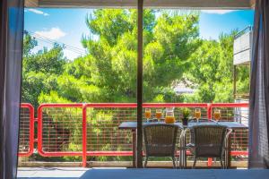 a table and chairs on a patio with a fence at Apollonia Hotel Apartments in Varkiza