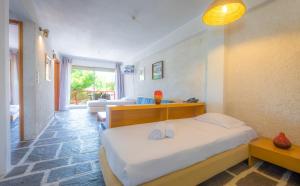a bedroom with a bed and a living room at Apollonia Hotel Apartments in Varkiza