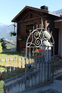 una cerca con una puerta delante de una casa en La maison de vali, en Aosta