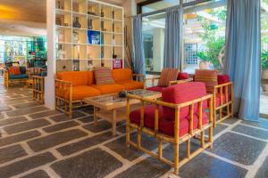 a room with couches and chairs and a table at Apollonia Hotel Apartments in Varkiza