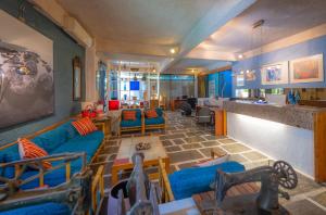 a living room with blue couches and a bar at Apollonia Hotel Apartments in Varkiza