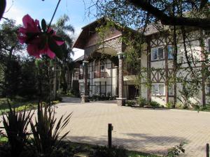 新彼得羅波利斯的住宿－Hotel Jardins da Colina，前面有粉红色花的房子