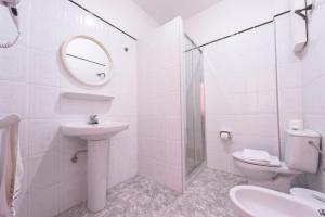 a bathroom with a sink and a toilet and a mirror at Apartamentos Las Casitas in Frontera