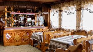 a restaurant with a bar with a table and chairs at Guest house Dvir Pysanka in Kosiv