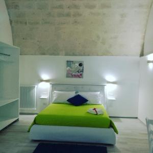 a bedroom with a green bed in a room at Domus ViLù in Matera