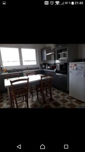 BlessyGîte chez Danielle的厨房配有桌子、两把椅子和冰箱