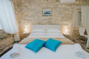 1 dormitorio con 2 camas y almohadas azules en Apartment Toma, en Trogir