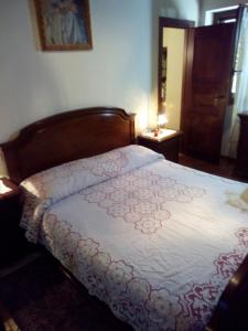 a bedroom with a bed with a white comforter at La Belle Maison in Siena