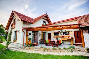 ein kleines Haus mit einer Terrasse und einem Tisch in der Unterkunft Apartmány Bobrík in Liptovský Mikuláš