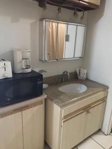 a kitchen with a sink and a microwave at Non Stop party Apartment Condo in San Juan