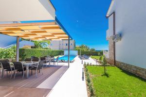 a patio with a table and chairs under a umbrella at Villa Marivel in Privlaka