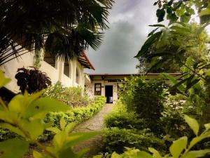 a building with a pathway leading into a yard at Hotel Minca - La Casona in Minca