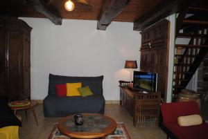 Maël-PestivienにあるMaison De Familleのソファとテレビのあるリビングルーム