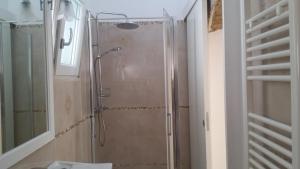 a bathroom with a shower with a glass door at Suite Pitagora in Bernalda