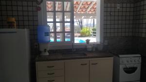 a kitchen with a sink and a window at Casa em Escarpas do Lago in Capitólio