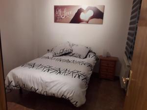 a bedroom with a bed with a white comforter at Apartamento Logroño in Logroño