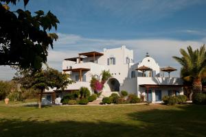 a large white house with a yard at Ammos Naxos Exclusive Apartments & Studios in Naxos Chora