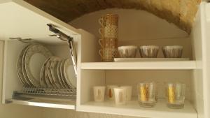 a shelf with cups and plates and bowls at Suite Pitagora in Bernalda