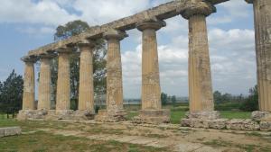 an ancient temple with columns in a field at Suite Pitagora in Bernalda