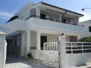 una casa blanca con una valla blanca en Casa di Rita al Bassamarea, en Porto Cesareo