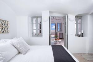 a white bedroom with a white bed and windows at Sweet nectar villa at Pyrgos with heated jacuzzi in Pyrgos +47 photos