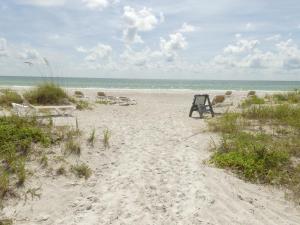a beach with chairs and the ocean in the background at Sand Glo Villas in Clearwater Beach