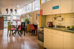 una cucina e una sala da pranzo con tavolo e sedie di Flying Dog Hostel a Lima