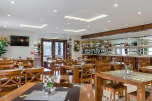 een restaurant met houten tafels en stoelen bij Villa D´Biagy Premium in Campos do Jordão