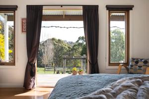 a bedroom with a bed and a large window at Old Chilli Daylesford in Daylesford
