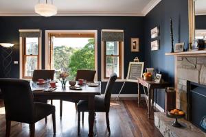 a dining room with a table and chairs and a fireplace at Old Chilli Daylesford in Daylesford