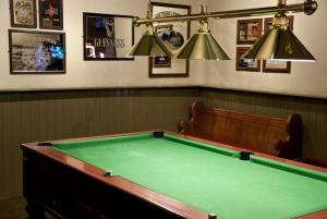 a pool table in a bar with two lights at Tricky's Hotel in Redruth