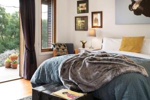 Un dormitorio con una cama con una manta. en Old Chilli Daylesford, en Daylesford