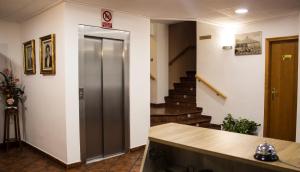 um corredor com uma porta e escadas num edifício em Pensión Mariola em Agres