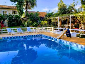 a swimming pool with a slide next to a house at Pousada Recanto dos Passáros in Brotas