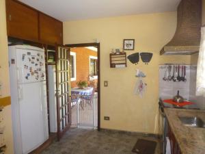 a kitchen with a white refrigerator and a table at Recanto de Oryon in São Pedro