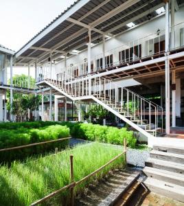 
a walkway leading to a building with a train on it at Krodyle Mindfulness House in Phra Nakhon Si Ayutthaya
