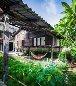 una casa antigua con una hamaca en el patio en Krodyle Mindfulness House en Phra Nakhon Si Ayutthaya