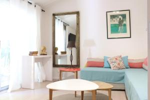 a living room with a couch and a mirror at Villa Melodie St Remy 6HA Piscine in Saint-Rémy-de-Provence