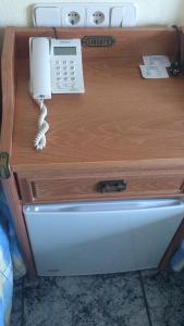 teléfono sentado sobre una mesa de madera en Hotel El Marino en Santiago de la Ribera