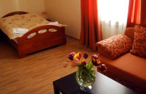 una habitación con un jarrón de flores sobre una mesa en AnRi Hotel, en Vatutinki