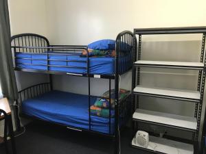 a room with two bunk beds with blue sheets at Dolphin Retreat Bunbury YHA in Bunbury