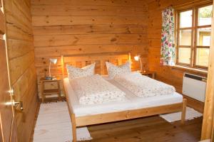 ein Schlafzimmer mit einem Bett in einer Holzhütte in der Unterkunft Ferienhaus am Zylinderberg in Zislow