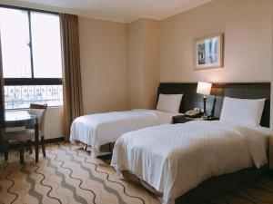 桃園區的住宿－中悅國際大飯店，酒店客房设有两张床、一张书桌和一个窗户。