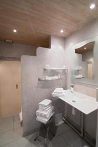 a white bathroom with a sink and a mirror at Hotel Bomotel in Montluçon