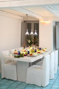 a white table with plates of food on it at Blue Angel Villa in Fira