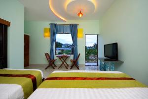 a hotel room with two beds and a television at Hoi An Sea Sunset Villa & Bar in Hoi An +73 photos