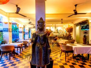 una estatua en medio de un restaurante con mesas en RESIDENCE WAT DAMNAk, en Siem Reap