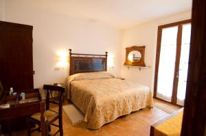 1 dormitorio con cama, mesa y espejo en Colle sul Lago, en Castiglione del Lago